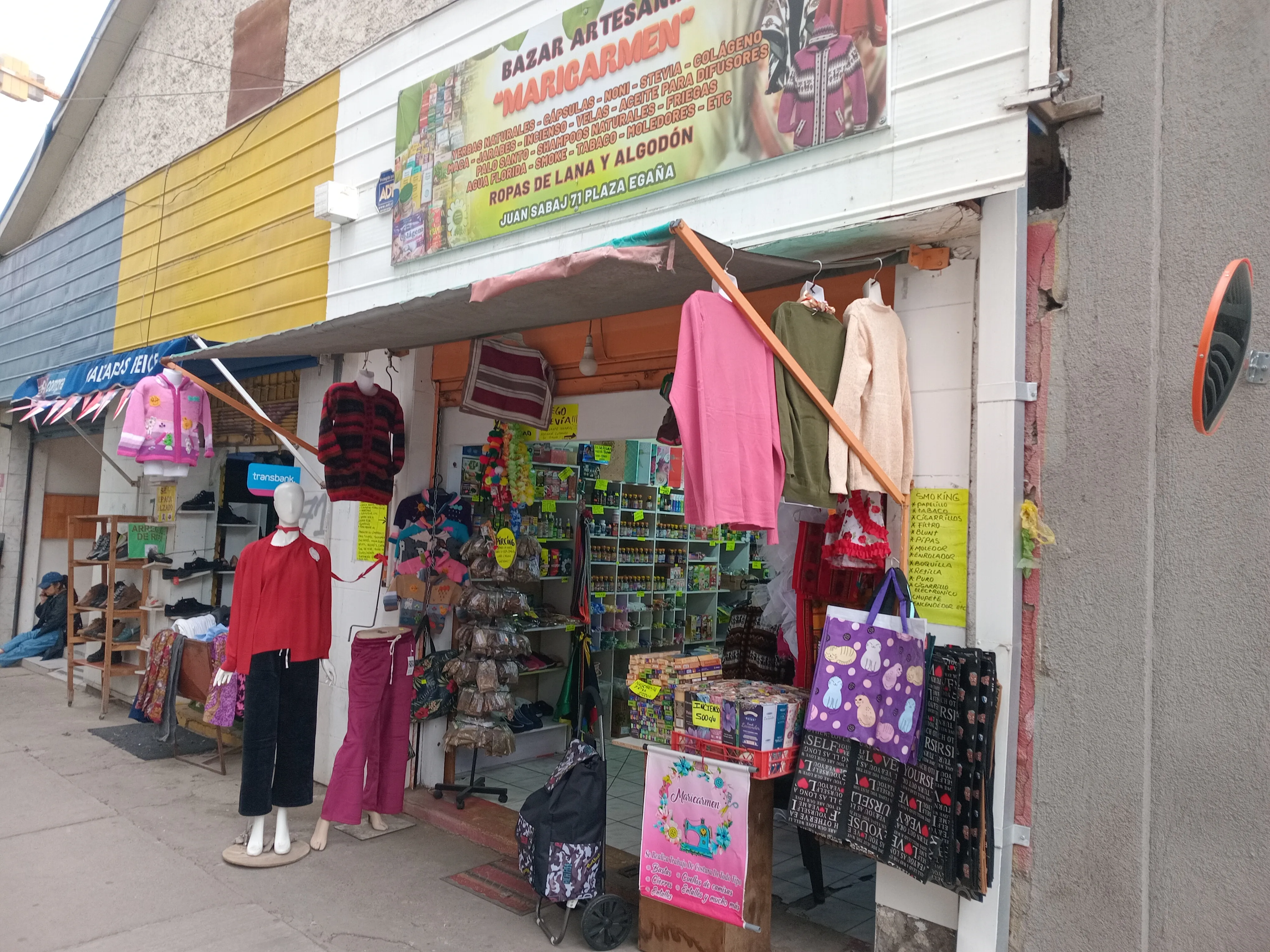 Fachada del Bazar Artesanía Maricarmen en Juan Sabaj 71, con ropa de lana colgada y estantes de productos naturales